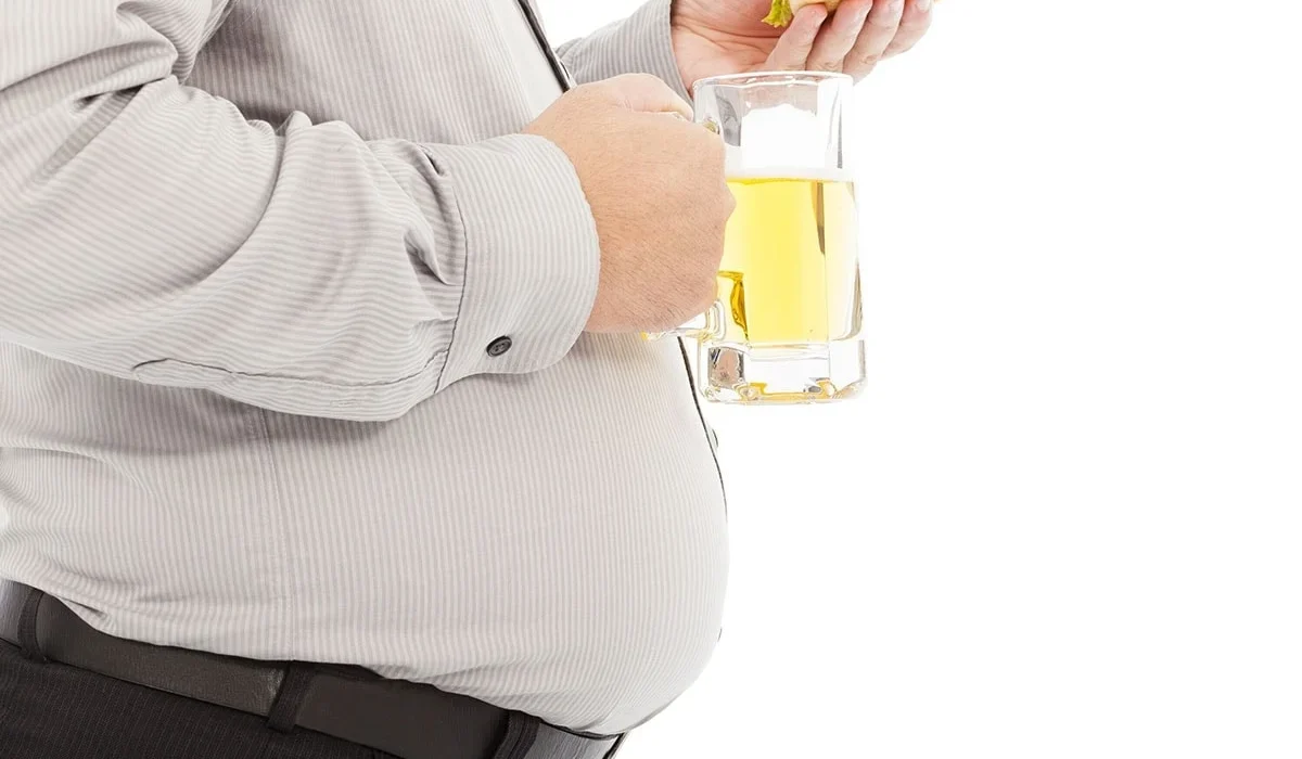 A picture of a man holding and drinking a glass of alcohol